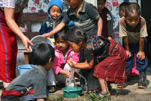 Very cute kids wash hands before coming back in from playing outside.